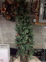 Full view of the 6-foot tall artificial pencil Christmas tree with ceramic base, slender shape and green pine foliage.