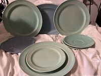 Collection of Lu-Ray pastel blue and greenish ceramic plates with a small oval Wedgwood plate in the back.