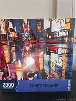 Front view of puzzle box showing Times Square night scene with reflections.