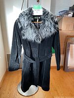 Full view of the black Rosebush coat on a mannequin showing the removable grey faux fur collar and belt.