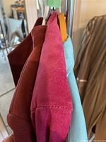 Side view showing texture and colors of three jackets - dark rust suede, magenta suede, and pastel blue faux leather.