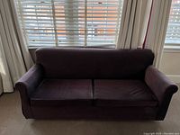 Front view of the purple upholstered 2-cushion sofa in closed sofa bed position.