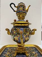 Front view of the painted decorative Russian electric samovar urn with matching teapot on top and tray behind