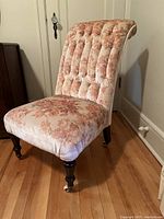 Front angled view showing tufted rolled backrest and floral upholstery