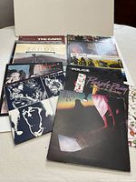 Twelve vinyl album covers fanned out on a white surface, showing titles and artwork