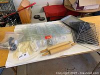 Photo of various baking and chocolate making molds, rolling pins, wire racks, a baking tray, and other accessories laid out on a table.