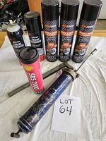 Photo showing three cans of emzone Brake & Parts Cleaner, two cans of Crack Off Engine Degreaser, a tube of Shell SP6-2000 Extreme grease, and a blue metal grease gun with a metal handle on a white cloth.
