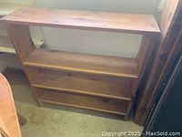 Brown solid wood shelf with three shelves shown fully assembled and in good condition