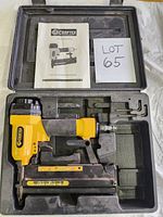 Craftex yellow and black 2-in-1 staple and nail pneumatic tool inside black molded plastic case with manual.