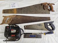 Three hand saws, one Skil jigsaw and one Irwin set square against white background