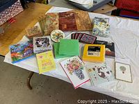 Photo showing three patterned fabric placemats, four coasters, several packs of napkins, assorted greeting cards, and envelopes spread on a table.