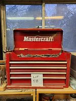Front view of open red Mastercraft tool chest showing outer appearance and raised lid