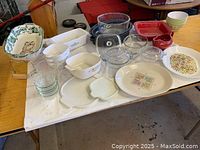 View of multiple assorted vintage Pyrex and glass baking dishes and bowls in various colors and shapes on a table.