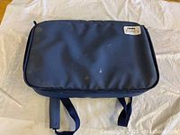 Closed view of the navy blue Pyrex branded portable container resting on a light-colored surface.