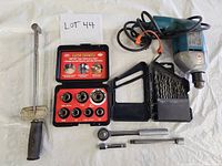 Photo of lot showing old style torque wrench, socket set with ratchet and extensions, electric corded drill, and drill bits holder.