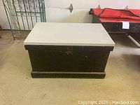 Closed solid wood storage trunk painted black with a grey top.