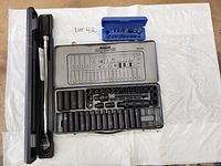 Two socket sets, one Maxximum in metal case and one in blue plastic case, with torque wrench in black plastic case.