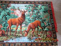 Full view of the tapestry showing three deer near a pond with natural forest background and detailed border.