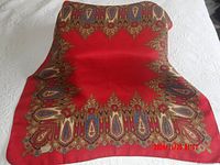 Full view of the folded red silk scarf showing central area and patterned border.