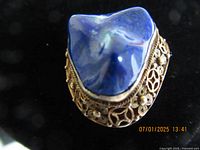 Close-up photo of the front side of the vintage silver filigree jewelry piece showing large blue stone and detailed silver filigree work.