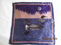 Front view of square scarf featuring loons on a lake at night with moon and forest silhouette