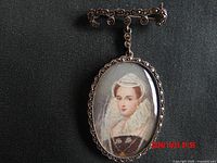 Front view of oval sterling silver brooch showing detailed portrait of a lady in period costume under glass dome.