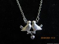 Image of sterling silver chain necklace with two dove pendant and dangling pearl on black velvet background