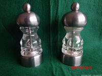 Front view of the pair of vintage Peugeot salt and pepper shakers showing clear glass and brushed metal parts, placed upright.