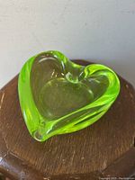 Heart-shaped ashtray on wooden surface under natural light