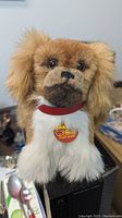 Front view showing the finely detailed face, original yellow tag and red collar of the mohair dog plush