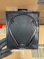 Front view of LG Tone Flex headset inside original transparent packaging showing neckband design.