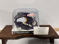 Mini football helmet in clear case showing autograph and Vikings logos