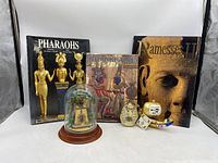 Full view of the three Egyptian books and two ornaments, including the pyramid with dome and ship sail ornament.