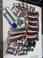 Overview of the lot showing various new model train track pieces, curved and straight, along with packaged accessories and electronic components.