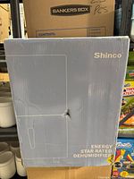Sealed box of Shinco SDZ1-120P dehumidifier showing front and branding.