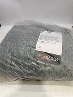Grey weighted blanket packaged in clear plastic with label showing Relax Eden brand and usage instructions.