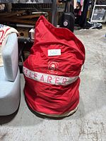 Red sail bag with white 'SEAFARER' lettering and number tag 522 attached, viewed from front.