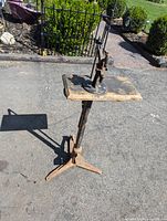 Full view of the antique tool on a wooden top and cast iron tripod base with a foot pedal, approximately 3 feet tall.