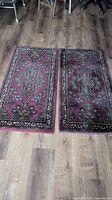 Pair of vintage Karastan rugs laid flat on wooden floor, showing full pattern and size.