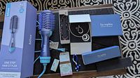 Bliss One Step Hair Styler in box with various necklaces and holy inspiration cards laid out on a surface.