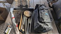 Photo of all items including Nesco shade poles, carrying case, brush, wind chimes, and tools on wooden surface.
