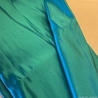 Folded length of turquoise silk satin showing sheen and color