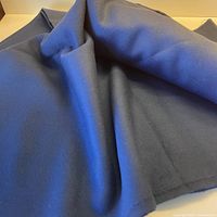 Folded blue wool fabric draped on surface