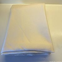 Folded pale butter-cream wool fabric showing overall size when folded