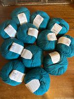 Top view showing all 12 teal yarn balls with labels