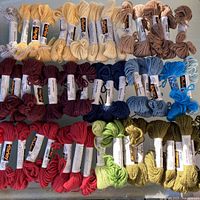 All 50 Parley wool skeins laid out by colour groups