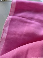 Edge and surface of pink rayon velvet showing selvage and texture