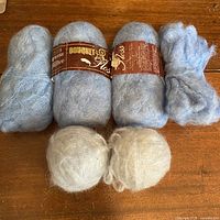 Full lot showing four blue skeins (two with labels) and two grey balls