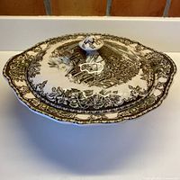 Top view of lidded bowl showing transferware pattern and scalloped rim
