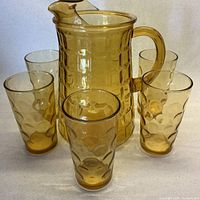 Pitcher center with five tumblers surrounding showing color and patterns